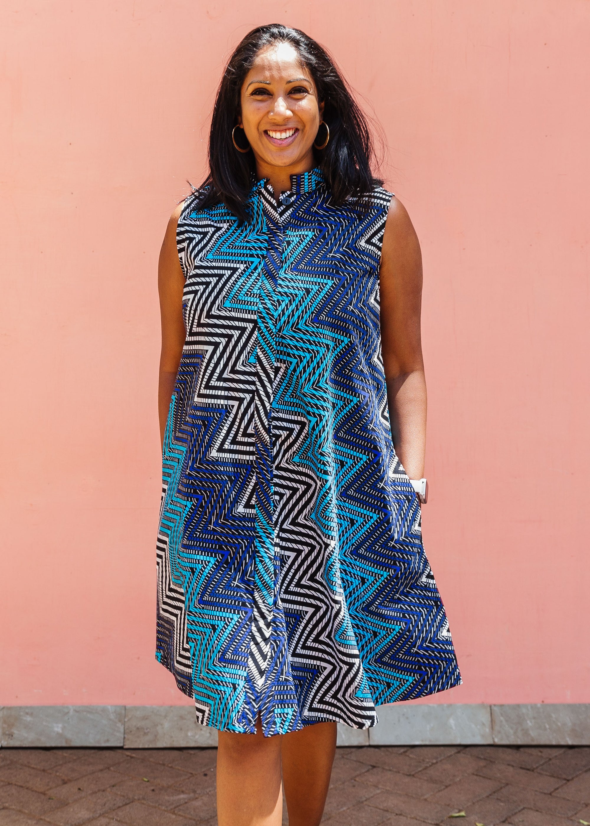 Model wearing blue, aqua and white zig zag print dress.